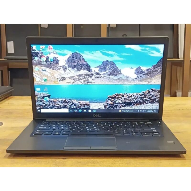 Matte black Dell Latitude 7490 business laptop open on a modern office desk setup.